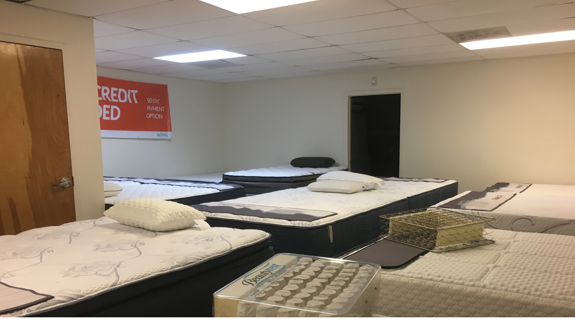 Display of premium pillows on a variety of mattresses, showcasing comfort and support options.