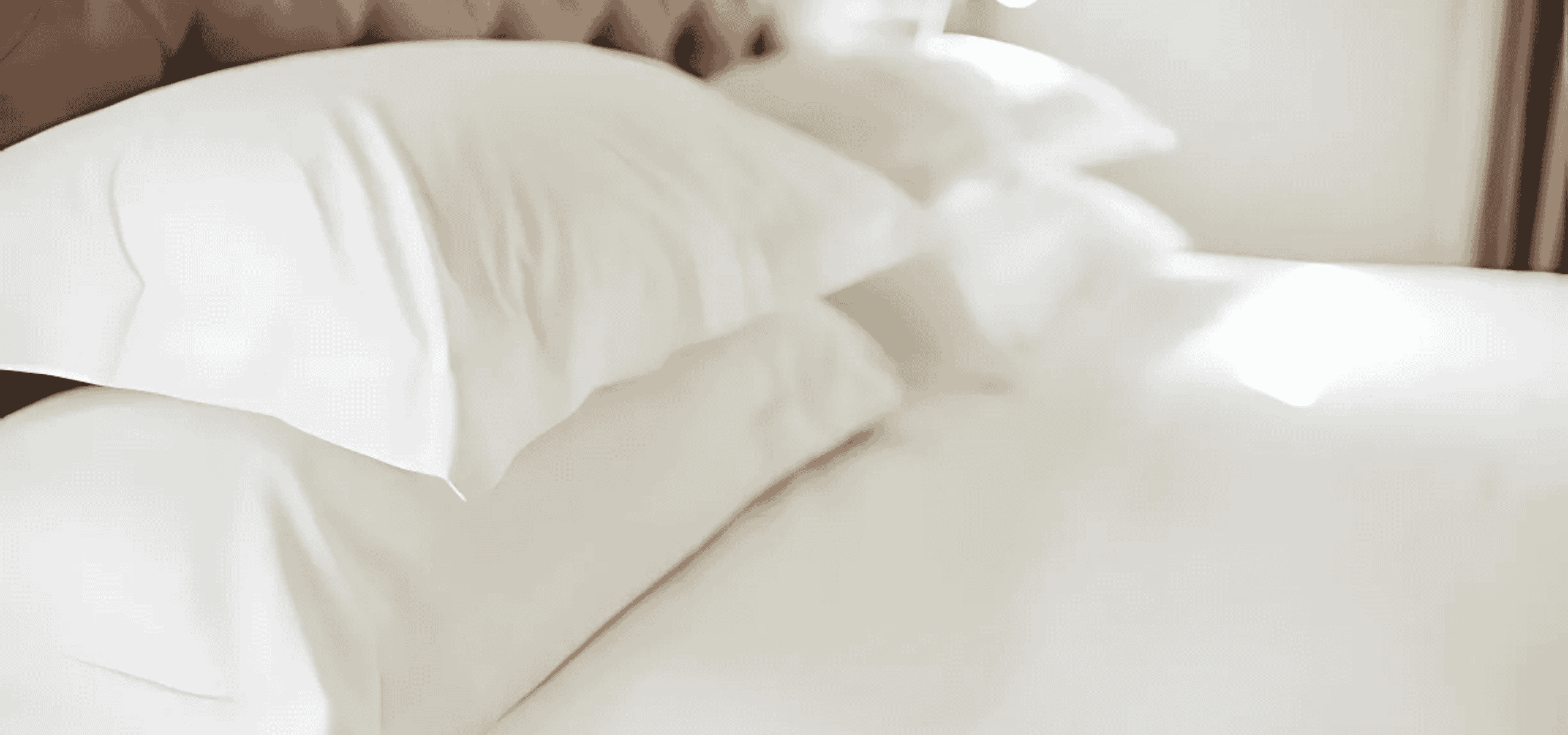 Fluffy white pillows stacked neatly on a cozy bed.